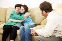 Woman and teenager hugging at therapy session